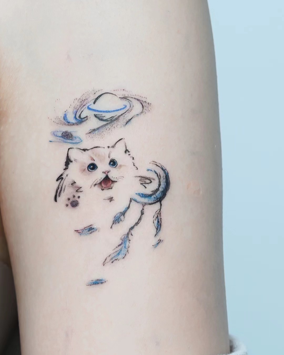 Small expressive pet tattoo with blue details