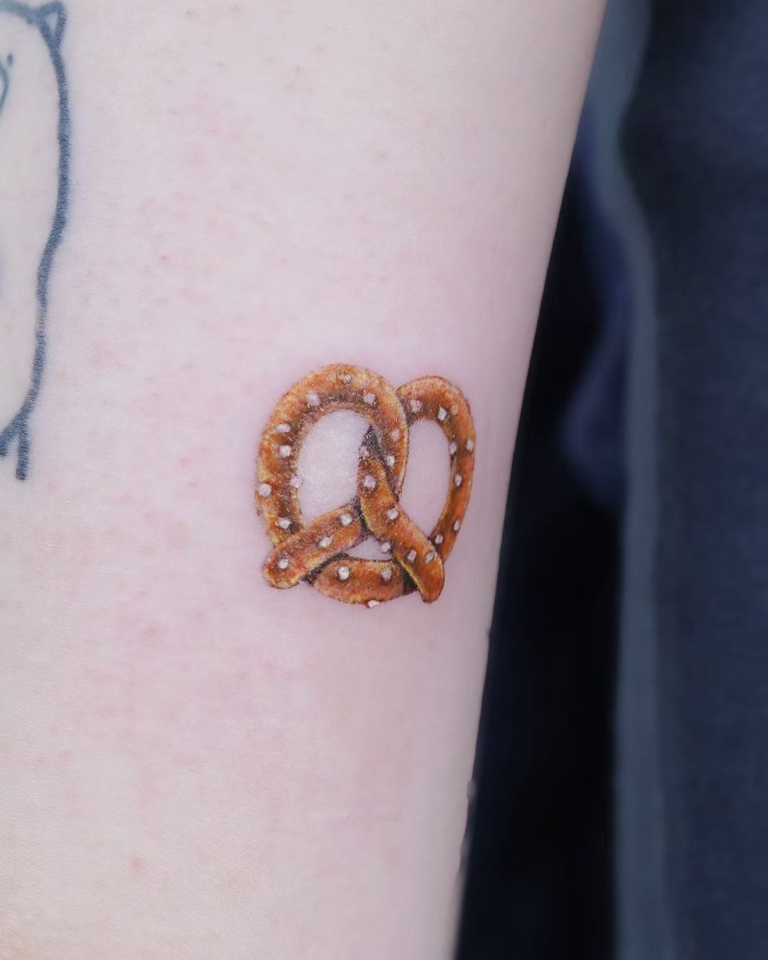 Small pretzel tattoo with golden colour